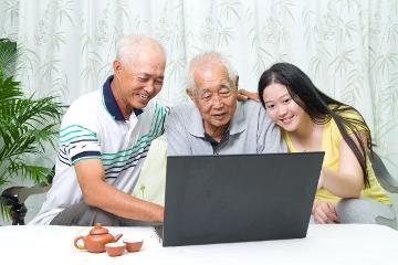 Three people using a laptop