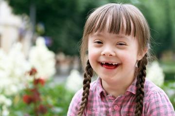 Young girl with Down's Syndrome smiling at camera