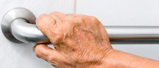 Elderly person using a mobility hand rail
