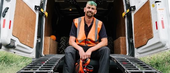 Council worker smiling while sat on van with ramp