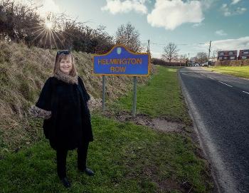 Councillor Elizabeth Scott by A690 road next to Helmington Row sign