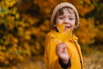 Happy child laughing and playing on an autumn day