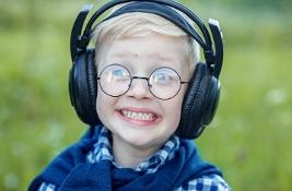 Cheerful little boy wearing headphones