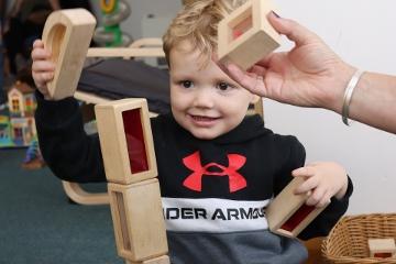 Small boy sitting on the floor playing with building blocks