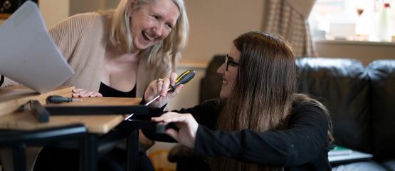 Two women using screwdrivers